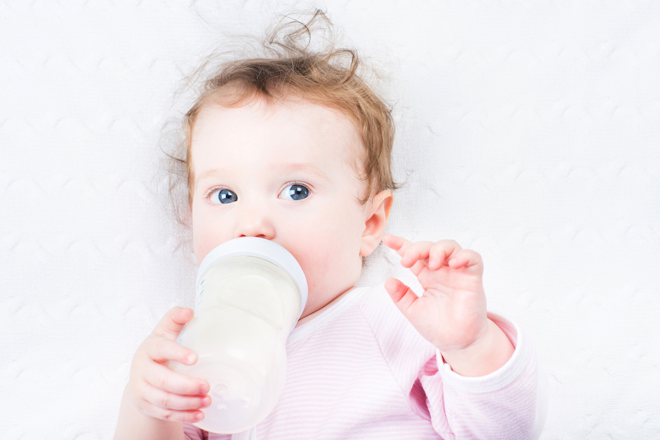 Donna che prepara latte in polvere per neonati a tavola al chiuso, primo  piano. Latte per bambini Foto stock - Alamy